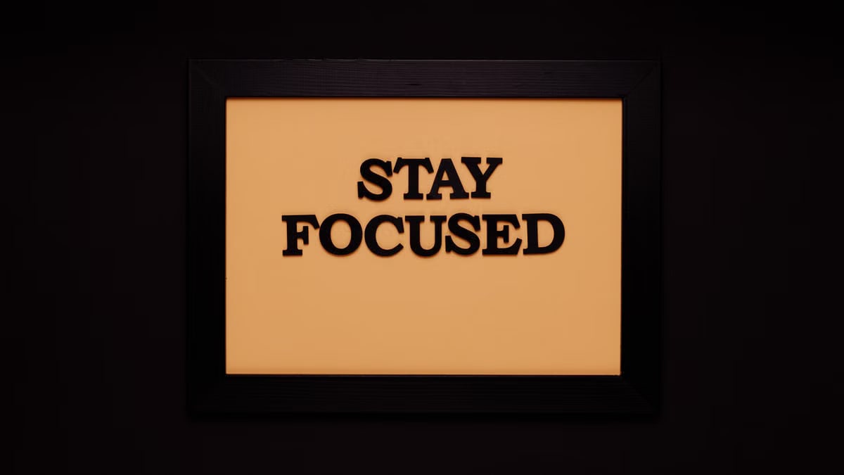 Minimalist black frame with 'Stay Focused' text on beige background.